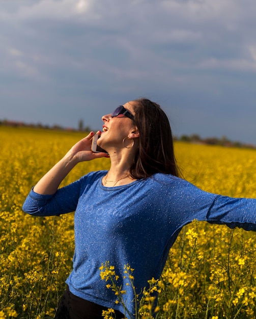 Foto mujer de pie en una flor amarilla en el campo