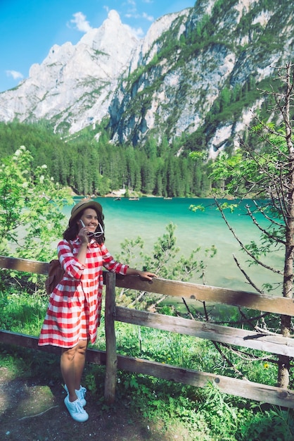 Mujer de pie frente al lago en las montañas