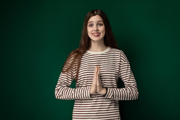 Mujer de pie frente a un fondo verde