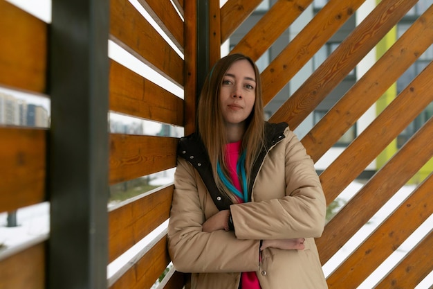 Foto mujer de pie frente a una pared de madera