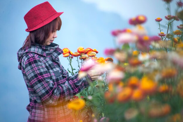 Foto mujer de pie junto a las flores en el campo