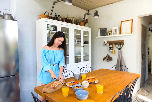 Foto mujer de pie junto a la mesa en casa