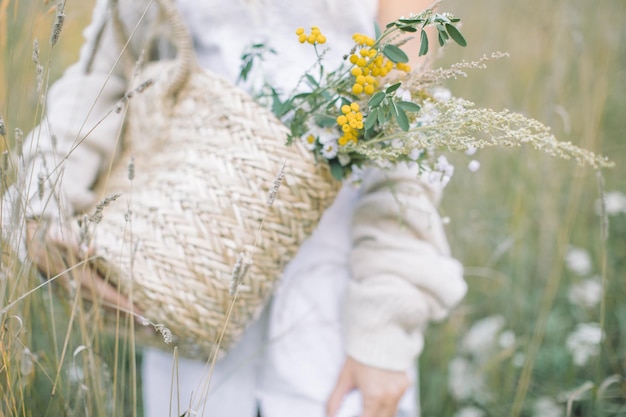 Mujer de pie junto a plantas de flores blancas