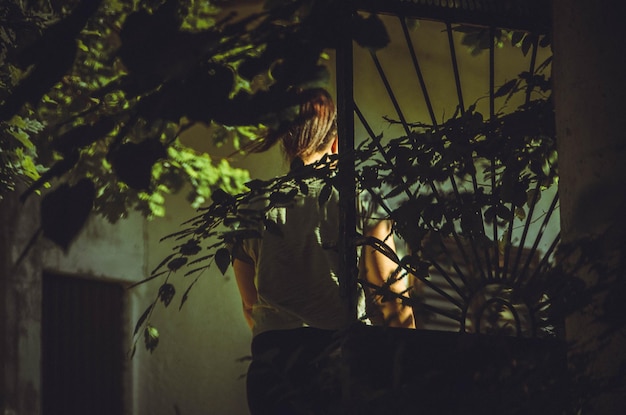 Foto mujer de pie junto a las plantas por la noche