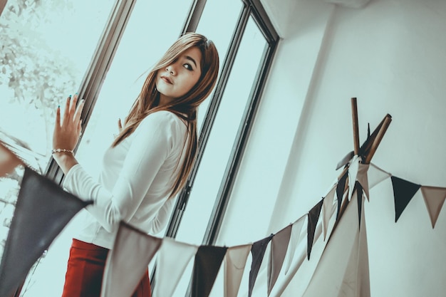 Foto mujer de pie junto a la ventana