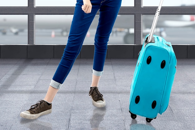 Foto la mujer de pie con una maleta en la terminal del aeropuerto
