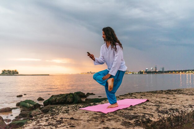 Foto mujer de pie en el mar contra el cielo durante la puesta de sol