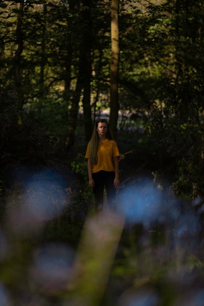 Foto mujer de pie en medio de los árboles en el bosque