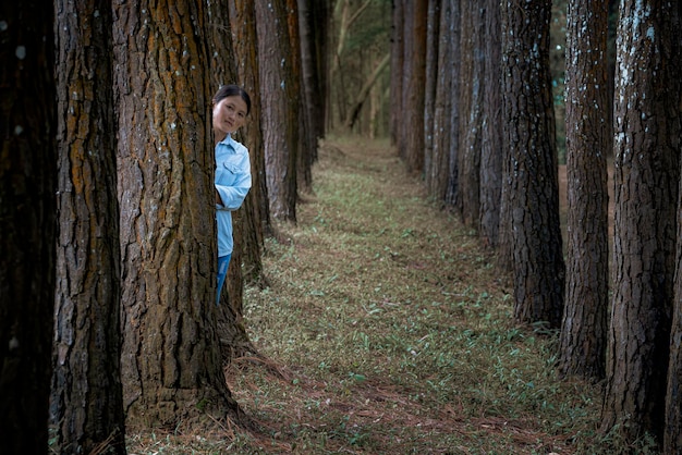 Mujer de pie en medio de los árboles en el bosque