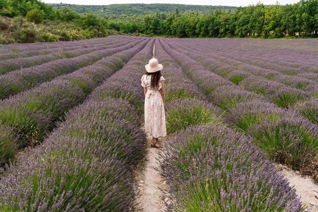 mujer de pie en medio de un campo de lavanda