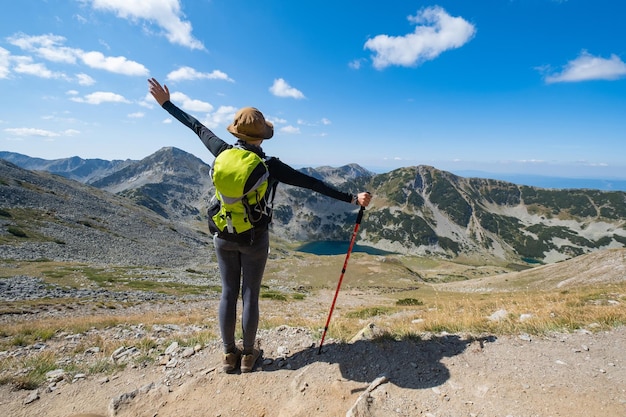 Foto una mujer está de pie en una montaña con los brazos extendidos