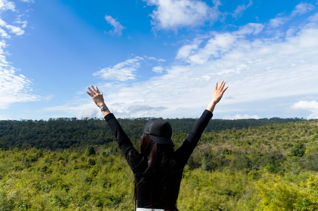 mujer de pie en la montaña con hermoso cielo azul