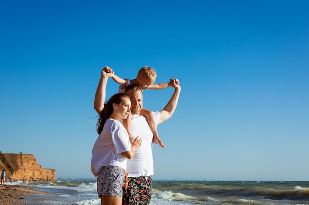 Foto mujer de pie en la playa contra el cielo azul claro