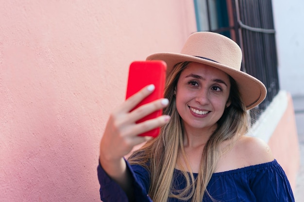 Mujer de pie tomando un selfie en una calle de la ciudad