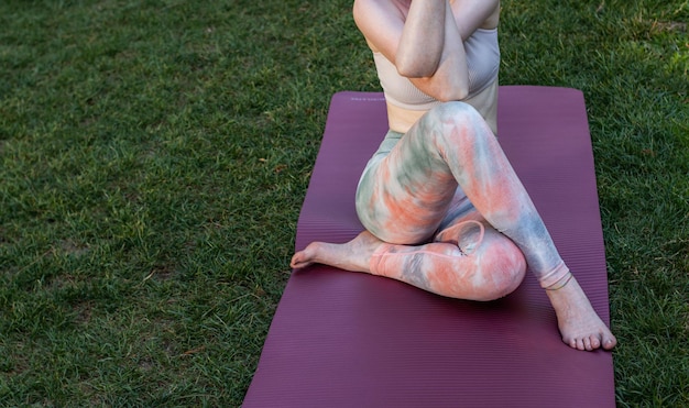 Una mujer de piel clara pelirroja practicando yoga y meditación en el bosque