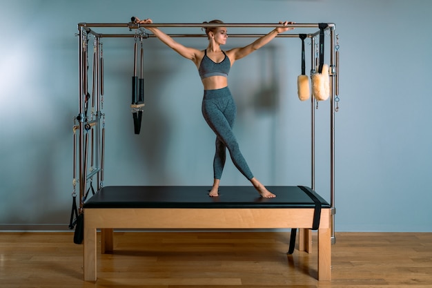 Mujer de Pilates haciendo ejercicios de estiramiento en el gimnasio