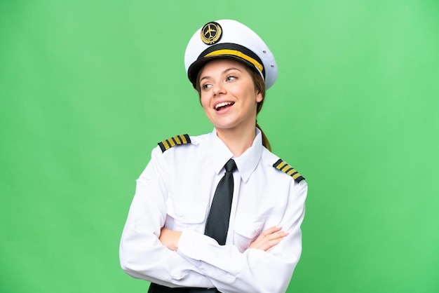 Mujer piloto de avión sobre fondo clave de croma aislado feliz y sonriente