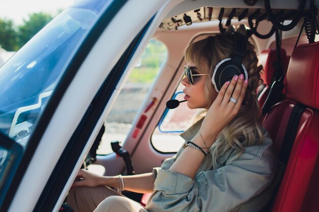 Foto mujer piloto en la cabina del helicóptero antes del despegue