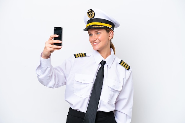 Mujer piloto caucásica de avión aislada de fondo blanco haciendo un selfie