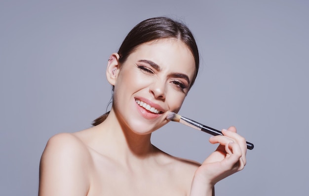 Mujer con pincel de maquillaje cuidado de la piel maquillaje y cosméticos rostro tratamientos de belleza