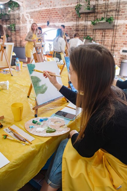 Foto mujer con pincel pintando sobre lienzo