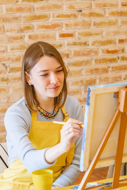 Mujer con pincel pintando sobre lienzo