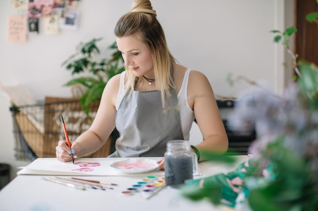 Mujer pintando en un libro en casa