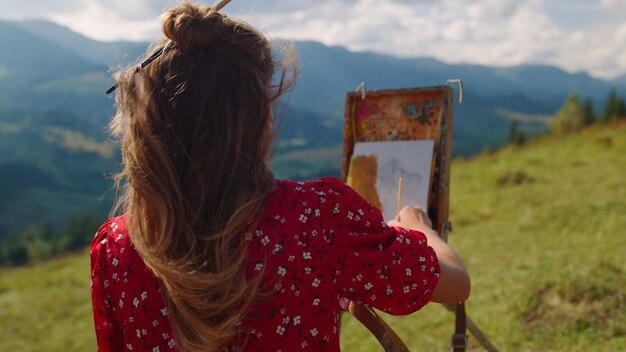 Foto una mujer pintando en un lienzo en un campo.