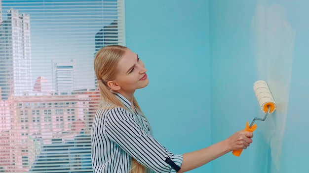 Mujer pintando una pared en la oficina