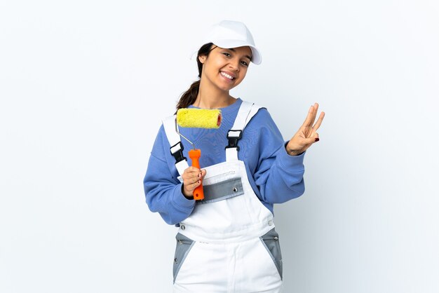 Mujer pintor sobre fondo blanco aislado feliz y contando tres con los dedos