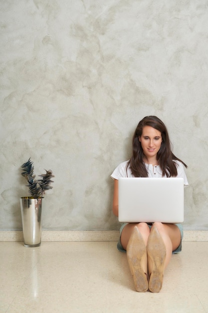 Mujer en el piso con su laptop