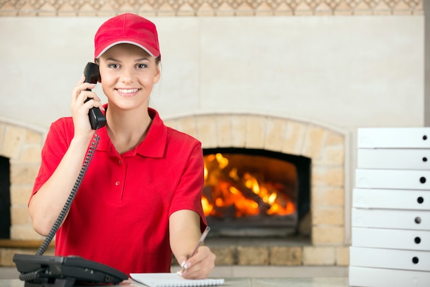 Mujer de pizza con pluma y diario para hacer el pedido.