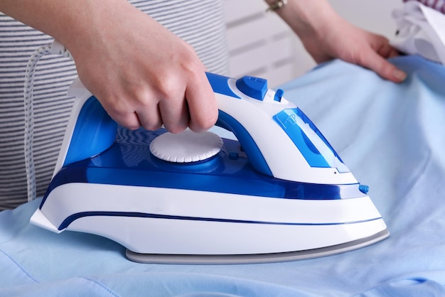 Mujer planchando ropa en la tabla de planchar closeup