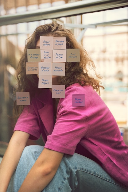 Mujer de plano medio posando con notas en la cara.