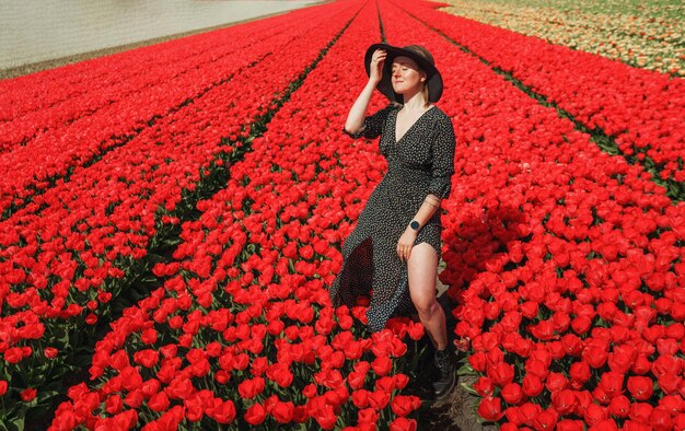 Mujer en una planta con flores rojas