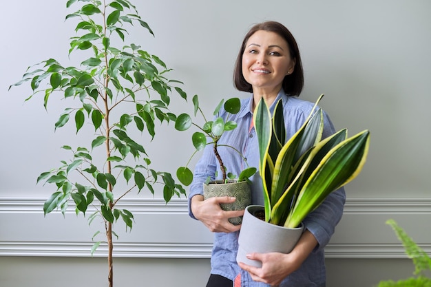 Mujer de plantas de interior de hobby verde con plantas en macetas
