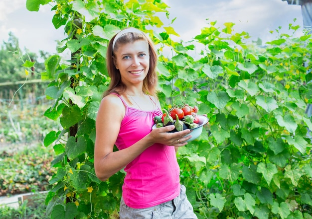 Mujer con un plato de verduras en el jardín