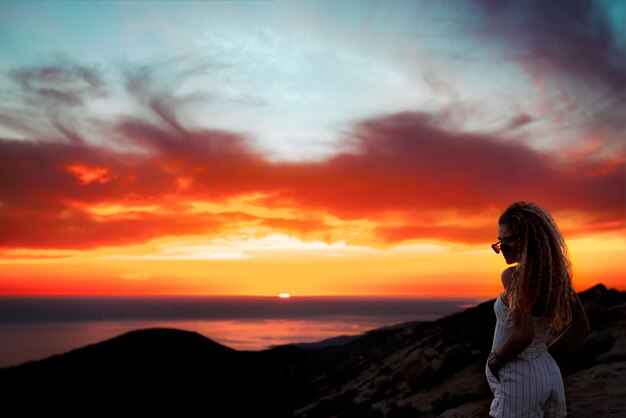 Foto mujer en la playa al atardecer