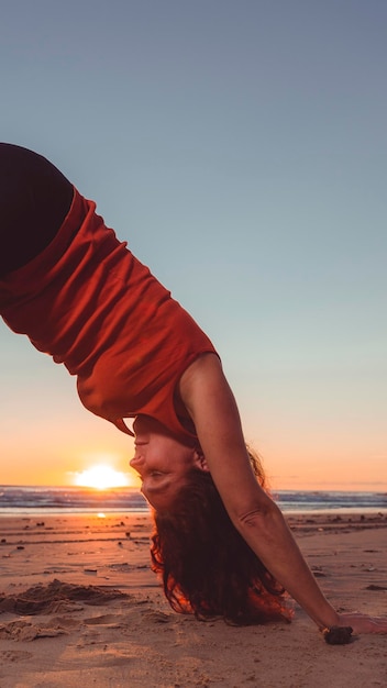 Mujer en la playa haciendo ejercicio al amanecer