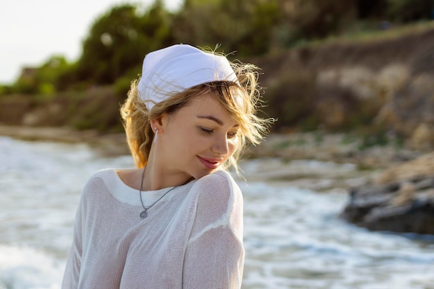 Mujer de playa en ropa de playa de moda chica turística caucásica en pareo blanco para protección solar relajante paseo en el agua del océano durante las vacaciones de verano