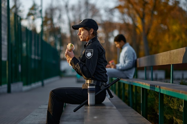 Mujer policía toma un descanso para comer en el parque