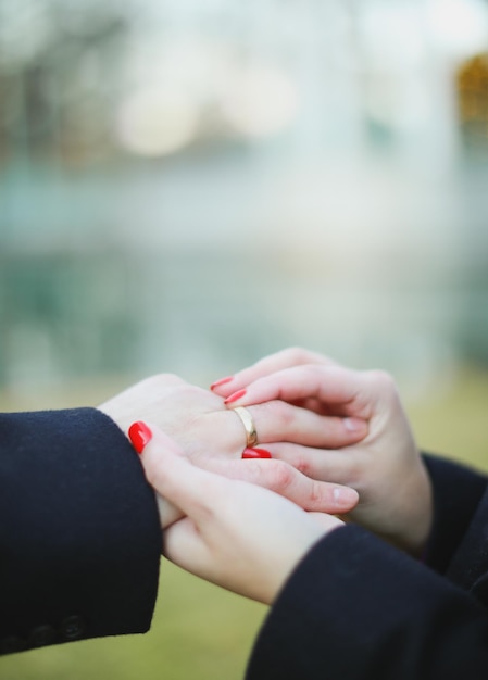 Una mujer pone un anillo en la mano de una mujer.