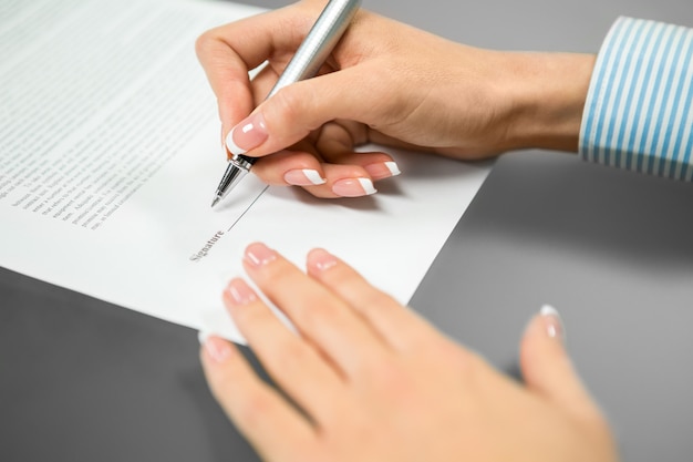 La mujer pone una firma. Necesita la última firma. Leer y firmar. Todo se entiende.