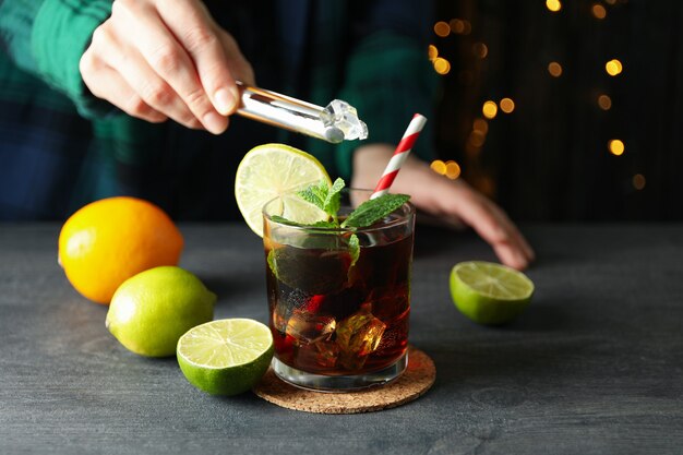 Mujer pone hielo en un vaso de Cuba Libre