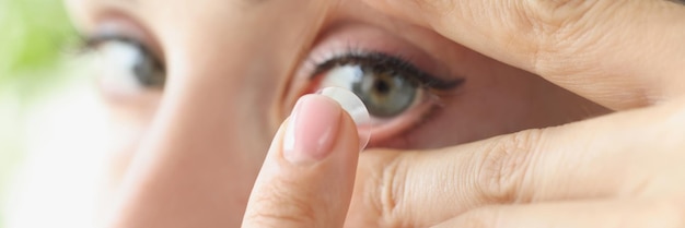 La mujer se pone lentes de contacto blandos sobre los ojos. Concepto de ajuste de lentes diarias