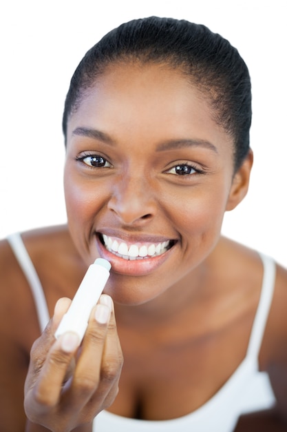 Mujer poniendo bálsamo labial en los labios