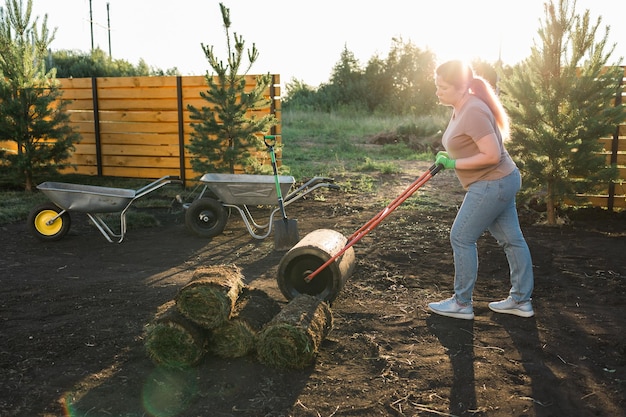 Mujer poniendo césped para el nuevo concepto de colocación de césped de césped de jardín