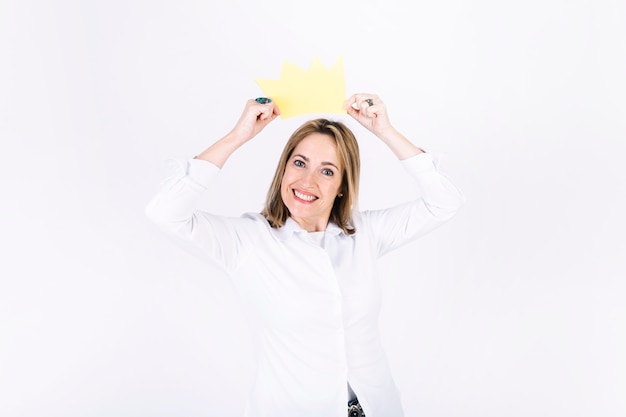 Foto mujer poniendo en la corona de papel