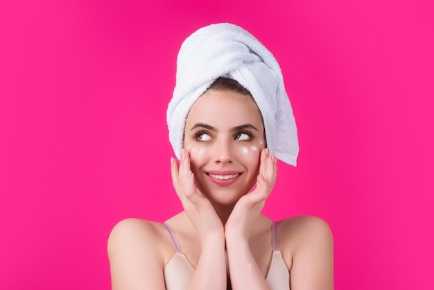 Mujer poniendo crema cosmética modelo de spa aplicando productos para el cuidado de la piel en su rostro maquillaje matutino