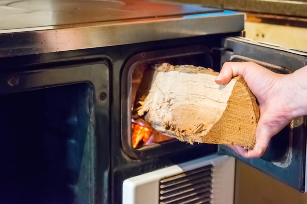 Foto mujer poniendo la madera en el fuego